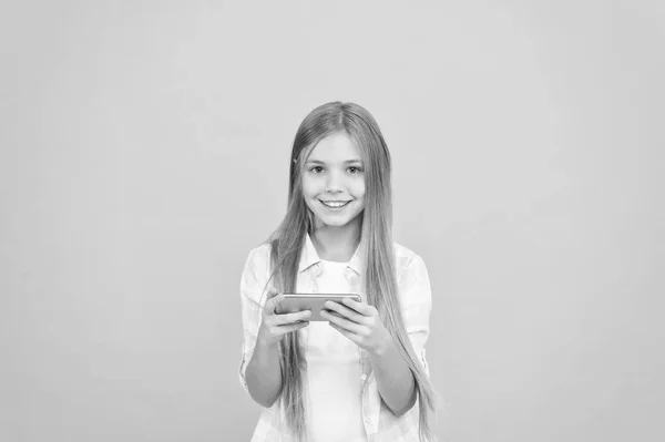 在线社交体验。小女孩用手机。小女孩与智能手机。可爱的儿童学习新技术。可爱的手机技术用户。在移动设备上观看视频 — 图库照片