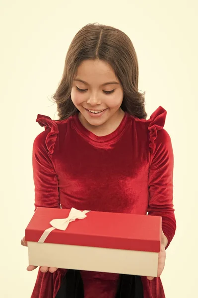 Niño niña en elegante vestido rizado peinado celebrar caja de regalo. Una niña emocionada por desempacar su regalo. Pequeña linda chica recibió regalo de vacaciones. Lo que hay dentro. Los mejores juguetes y regalos de Navidad para niños —  Fotos de Stock