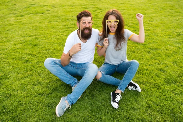 Homem barbudo hipster e bonita mulher rostos alegres. Jornada da juventude. Casal no amor adereços de cabine de jovens alegres. Casal namoro. Casal despreocupado se divertindo gramado verde. Pessoas emotivas. Entretenimento de verão — Fotografia de Stock