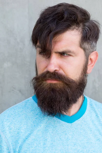 O meu cabelo fala por si. Cara séria vestindo barba em forma e cabelo de estilo. Hipster peludo com barba elegante e cabelo bigode na parede cinza. Homem barbudo com pêlos unshaven rosto e corte de cabelo na moda — Fotografia de Stock