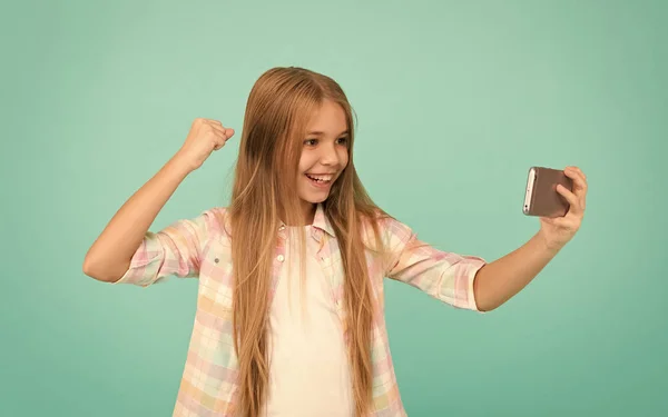 Isso é espantoso. A ver vídeo no dispositivo móvel. Menina usando telefone celular. Criança menina pequena com smartphone. Criança adorável aprendendo novas tecnologias. Bonito usuário de tecnologia de telefone móvel — Fotografia de Stock