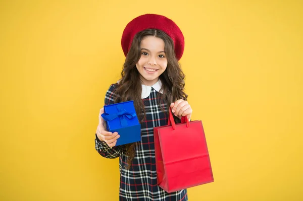 Gelukkige kinderdag. modieuze winkelverslaafde. Kindermode. gelukkig meisje in franse baret. kind met kistje op gele achtergrond. Een klein meisje heeft een boodschappentas. winkelverkoop. Gelukkige verjaardag. — Stockfoto