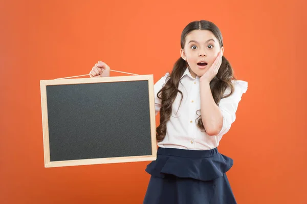 Oh, Dios mío. alumno sorprendido en uniforme escolar. espacio de copia. comercialización comercial conept. anuncio de la escuela de negocios. nueva idea de compras. ventas en el mercado escolar. señalización. chica de la escuela sorprendida con pizarra — Foto de Stock