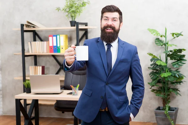 Drinking coffee relaxing break. Boss enjoying energy drink. Caffeine addicted. Start day with coffee. Man bearded businessman hold coffee cup stand office background. Successful people drink coffee