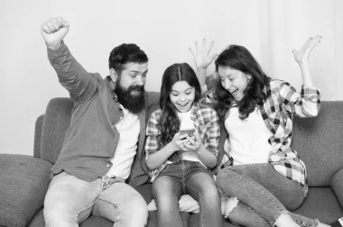 Evde mutlu bir aile. Küçük kız anne ve babasıyla smartphone kullanın. Aile mutlu ruh hali ile. Mutlu aile selfie. Sakallı erkek ve kadın kızı çocuk ile. Mutlu bir aile. Eğleniyor