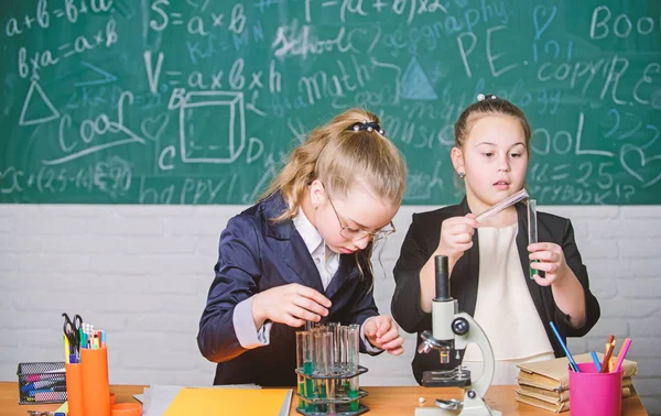 Realizar reacciones químicas. Conocimiento básico de la química. Haz que estudiar química sea interesante. Concepto de experimento educativo. Las compañeras estudian química. Microscopio y tubos de ensayo en la mesa — Foto de Stock