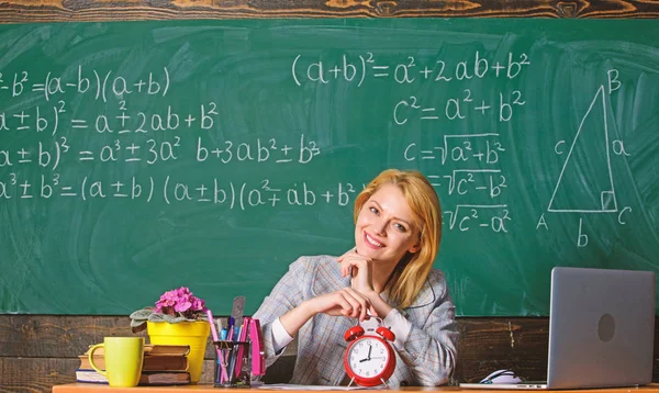 Tómate tu tiempo. profesor con despertador en pizarra. El tiempo. Estudio y educación. Escuela moderna. Día del conocimiento. En la escuela. Enseñanza en casa. Mujer feliz. De vuelta a la escuela. Día del maestro. mujer en el aula — Foto de Stock