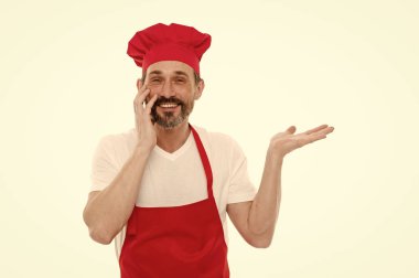 Ürün sunmak. Chef şapka ve bir kenara el işaret önlük sakallı olgun adam. Üst düzey aşçı sakal ve bıyık önlük önlük giyiyor. Kırmızı önlük, kopya alanı pişirme olgun şef aşçı