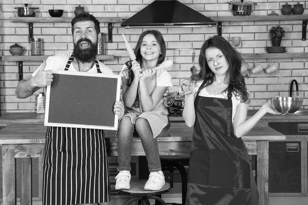 Cuisiner ensemble. Famille maman papa et fille portent des tabliers debout dans la cuisine. Cuisine concept de nourriture. Préparez un délicieux repas. Petit déjeuner. La famille s'amuse à cuisiner ensemble. Enseigner aux enfants à cuisiner — Photo