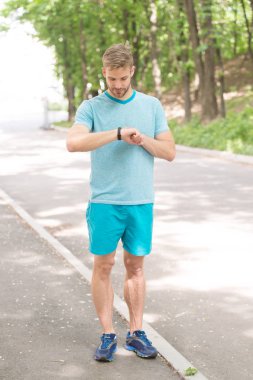 Spor saati. Adam dışarıda spor yapıyor. Spor giyim modası. Sağlık ve zindelik. Sporcu enerji dolu. Sporcu sportif aktiviteler yapıyor. Spor saatiyle izleme eğitimi. fitness bilekliği