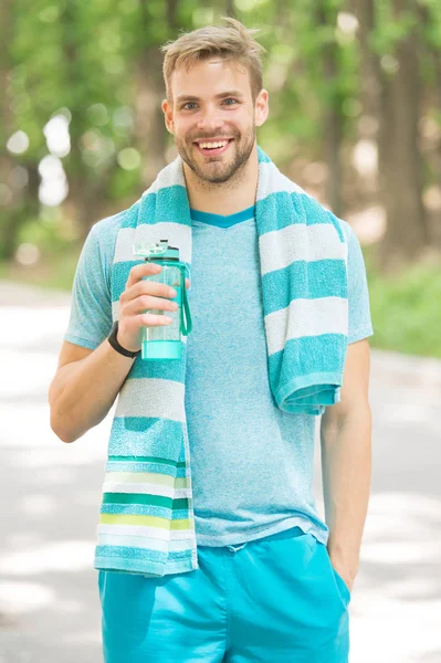 Sabah koşusundan sonra susamış. Atlet şişe bakımı hidrasyon vücut tutun. Büyük egzersiz sonrası ferahlatıcı vitamin içeceği. Adam atletik görünüm su şişesi tutar. Atlet su içer. Su dengesi — Stok fotoğraf