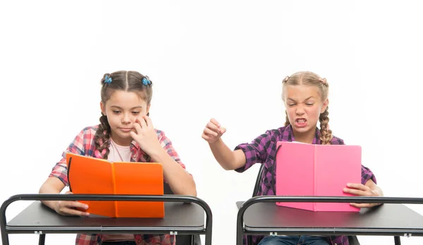 La actitud personal determina el éxito. Adquirir conocimiento. Chicas pequeñas con libros se sientan en los escritorios de lectura de la lección. Los niños pequeños aprenden a leer y escribir en la escuela. Habilidades de lectura. Impresión opuesta — Foto de Stock