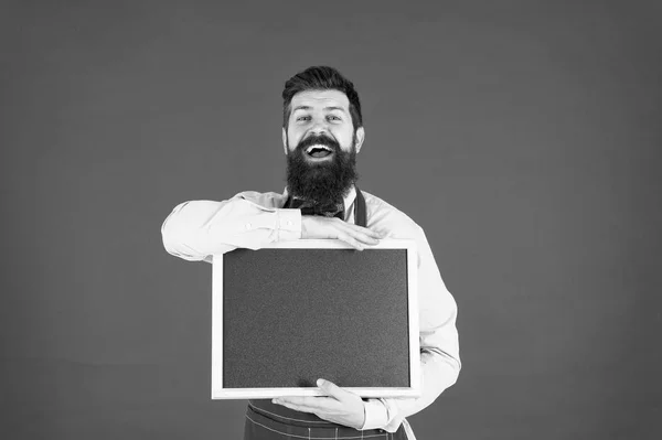 Vendas de supermercado. placa de menu. Chef homem feliz com quadro-negro em branco, espaço cópia. Grande cozinha. cozinhar por receita. Bem-vindos. Restaurante ou café publicidade. Cozinheiro hipster barbudo em avental. supermercado — Fotografia de Stock