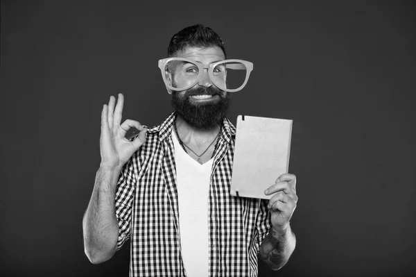 Seine ok. studie nerd einladend zum lesen von buch. männlicher Student mit Vorlesungsnotizen. bärtiger Mann mit Parteibrille und Lehrbuch. Buch-Nerd mit schicker Brille — Stockfoto