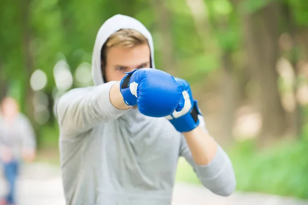 Nice punch. Boxing training endurance. Man athlete concentrated face with sport gloves practicing boxing nature background. Boxer ready to fight. Sportsman boxer training with boxing gloves