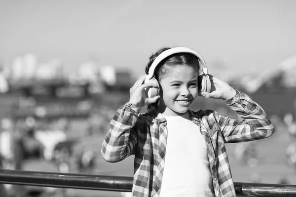 Girl child listen music outdoors with modern headphones. Kid little girl listen song headphones. Music account playlist. Customize your music. Discovering new music styles is great way into culture