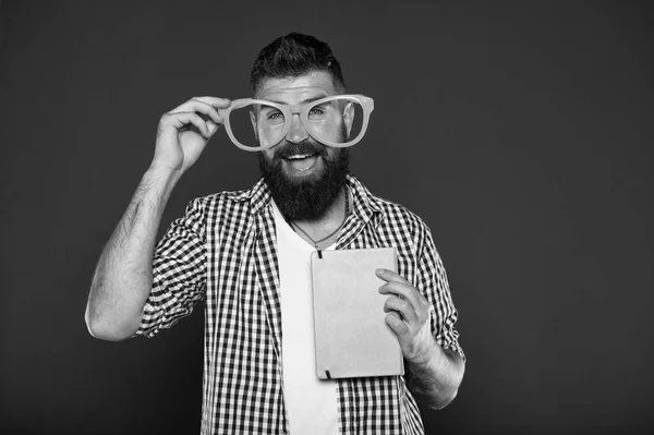 Super smart. Manliga universitetsstudent med föreläsningsanteckningar. Bok nörd fancy glasögon. Skäggig man i part glasögon med lektion bok. Studera nörd håller bok — Stockfoto