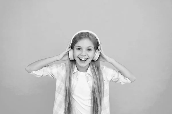 Ela é uma grande fã de música. Criança feliz gosta de música tocando em fones de ouvido. Criança escutando música. Adorável amante da música. A música deixa-a feliz — Fotografia de Stock