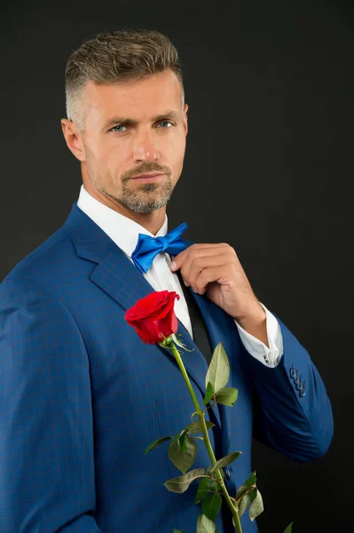 Saint Valentin et anniversaire. Services de rencontres. Comment être romantique. Concept perfectionniste. Un gentleman romantique. Homme mature macho confiant avec un cadeau romantique. beau gars rose fleur romantique date — Photo