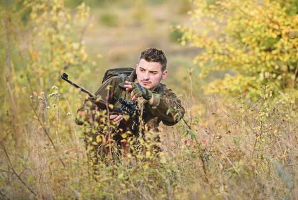 Cazar es un pasatiempo masculino brutal. Temporadas de caza y captura. Barbudo cazador serio pasar tiempo libre de caza. Cazador de rifle. El hombre usa ropa de camuflaje fondo de la naturaleza. Permiso de caza —  Fotos de Stock