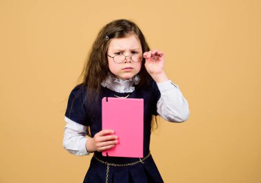 ciddi küçük kız öğretmen olmak istiyor. ev işi. günlük notları için not defteri. çalışma dersi. bilgi ve eğitim. Okula geri dön. kağıt klasörü ile küçük kız. Kendine güvenen mezun