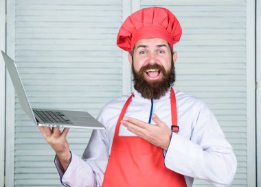 Hipster şapka ve önlük ürünleri online satın almak. Online alışveriş. Teslimat hizmeti. Adam şef yiyecek pişirme online malzemeler arıyor. Market online. Mutfakta şef dizüstü bilgisayar. Aşçılık okulu