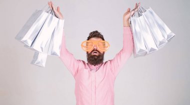 Happy shopping with bunch paper bags. Shopping addicted consumer. How to get ready for your next vacation. Man bearded hipster wear sunglasses while carry lot shopping bags. Shopping on black friday clipart