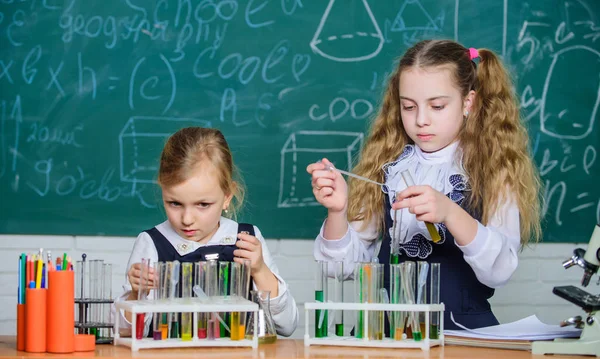 Reageerbuisjes met kleurrijke stoffen. Chemische analyse en observatie reactie. School apparatuur voor laboratoria. Meisjes op school chemie les. School laboratorium partners. Kinderen bezig met experiment — Stockfoto