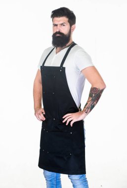 Yaşayan hipster yaşam tarzı. İş önlükuzunuzun sakallı ve bıyıklı hipster. Sakallı hipster berber veya pişirme önlük giyiyor. Sakallı traşsız yüzü ve şık saçları olan Hipster adam