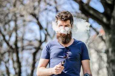 Sakallı vahşi erkek elektronik sigara içiyor. Sakallı olgun hipster. adam sigara e-sigara. hipster adam vaping cihazı tutun. Sağlık güvenliği ve bağımlılık. buharı teneffüs. Mükemmel sakal