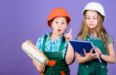 mühendislik fikri. küçük kızlar atölyede birlikte tamir. İşçi bayramı. 1 mayıs. Tablet ve rulo ile kask küçük çocuklar. Foreman müfettişi. Onarım. Sanırım sorunu biliyorum.