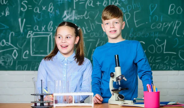 Educación escolar. Chica y niño se comunican mientras realizan el experimento escolar. Niños estudiando juntos en el aula. Análisis químico. Los niños estudian química. Lección de química escolar. Laboratorio escolar — Foto de Stock