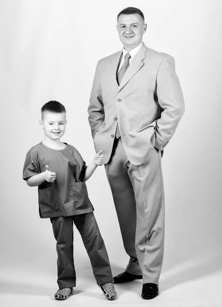 Dad boss. Father and cute small son. Child care development upbringing. Respectable profession. Man respectable businessman and little kid doctor uniform. Family business. Doctor respectable career — Stock Photo, Image