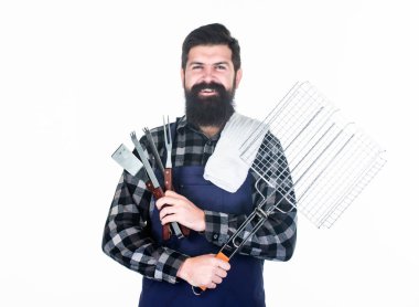 Kavurma ve ızgara yemeği. Adam pişirme gereçleri barbekü tutun. Açık havada et kavurma araçları. Piknik ve barbekü. Et pişirmek için ipuçları. Barbekü mevsimi. Sakallı hipster barbekü için önlük giymek