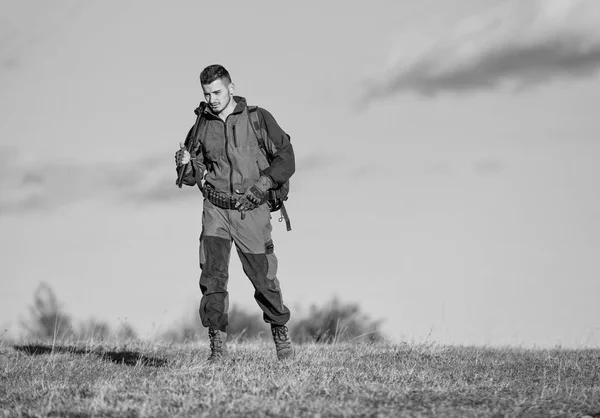 Guy lov přírodní prostředí. Maskulinní hobby činnost. Lovecké zbraně pistole nebo pušky. Muž lovec nosit rifle modré obloze na pozadí. Zkušenosti a praxe propůjčuje úspěchů při lovu. Hobby lovecký — Stock fotografie