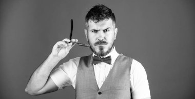 Keskin jilet. Berber dükkanında düz usturalı sakallı adam. Sakallı, tıraş usturası tutan acımasız bir adam. Tıraş sakalı için retro jiletli hipster. Vintage berber aracı ile Berber. Jilet berber dükkanı