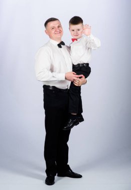 Baba sarılmak oğlu resmi giysi kıyafeti taşır. Büyüyün beyefendi. Centilmen yetiştirilme tarzı. Küçük oğul soylu bir adam babaları örnek takip. Aile tatili. Baba ve oğul ilişkileri. Centilmen yetiştirme