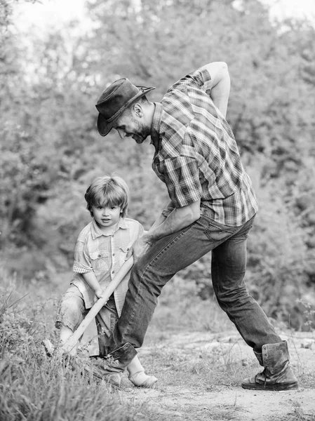 宝物を見つける。シャベルを持った小さな男の子と父親が宝物を探しています。幸せな子供時代宝物のための冒険狩り。庭で働く小さなヘルパーシャベルで楽しむ自然の中でかわいい子供 — ストック写真