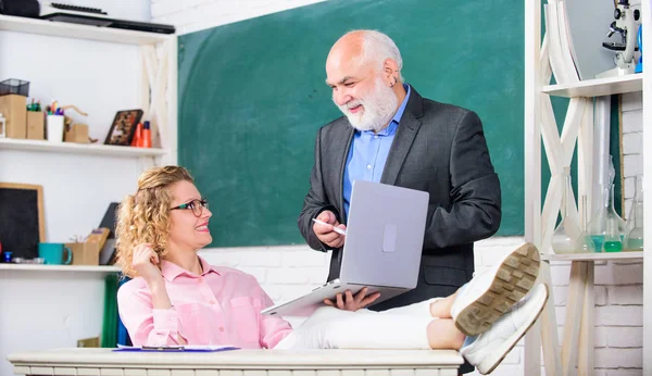 Diskutera ämne med elev eller kollega. Man mogen skollärare och sorglös tjej elev med laptop. Moderna skolan. High School College University. Kommunicera tydligt och effektivt — Stockfoto