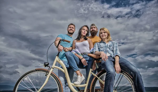 Share or rental bike service. Group friends hang out with bicycle. Bicycle as best friend. Company stylish young people spend leisure outdoors sky background. Cycling modernity and national culture