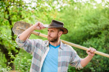 mutlu dünya günü. Eko yaşam. seksi çiftçi kürek tutun. Eko çiftlik. Hasat. tarım ve tarım saldirisi. Bahçe ekipmanları. kovboy şapkalı kaslı çiftlik adamı. Çiçeklerin iyi bakıma ihtiyacı var.