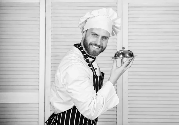 Homem confiante no avental e chapéu segurar bandeja. Cozinhe no restaurante, uniforme. O homem barbudo adora comer. chef pronto para cozinhar. Profissional na cozinha. cozinha culinária. Bem-vindo no mundo dos gostos — Fotografia de Stock