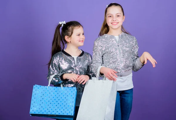 Ontdek iets nieuws. Meisjes zusters vrienden met winkelen tassen Violet achtergrond. Winkelen en kopen. Zwarte vrijdag. Verkoop en korting. Dagje winkelen. Kinderen bos pakketten. Kids Fashion — Stockfoto