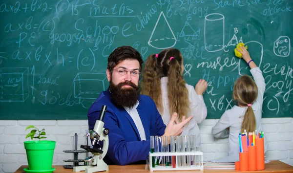 Explaining biology to children. How to interest children study. Fascinating biology lesson. School teacher of biology. Man bearded teacher work with microscope and test tubes in biology classroom