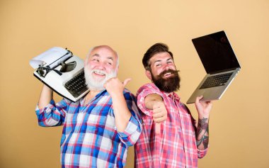 Dijital teknolojiler. Teknoloji savaşı. Eski nesil. Erkekler yazma aletleriyle çalışır. Modern yaşam ve geçmişin kalıntıları. Daktilove hipster dizüstü bilgisayar ile kıdemli adam. Yeni teknolojilere hakim