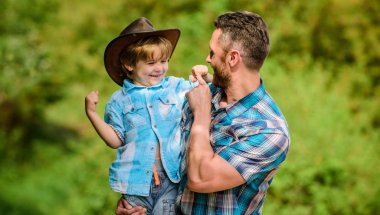 Bahçede küçük bir yardımcı. Küçük çocuk ve baba doğa arka plan. Macera ruhu. Babam gibi güçlü. Güç baba olmak. Çocuk eğleniyor kovboy baba. Rustik bir aile. Büyüyen sevimli kovboy