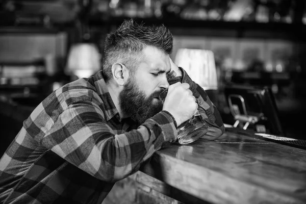 Человек с бородой проводит досуг в темном баре. Жестокий бородатый хипстер сидит за барной стойкой и пьет пиво. Хипстер отдыхает в баре с пивом. Закажи алкоголь. Бар расслабляющее место выпить и расслабиться — стоковое фото