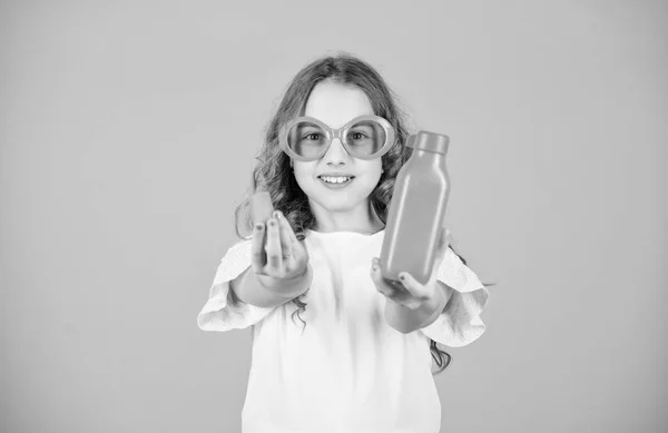 Βιταμίνη διατροφής. Μόδα παιδί γυαλιά ηλίου πίνουν αναζωογονητικό χυμό βιταμίνης. Υγειονομική περίθαλψη. Καλοκαιρινή δίαιτα βιταμινών. Καλή παιδική ηλικία. Φυσική πηγή βιταμινών. Κορίτσι τρώνε καρότο λαχανικών και πίνουν χυμό καρότο — Φωτογραφία Αρχείου