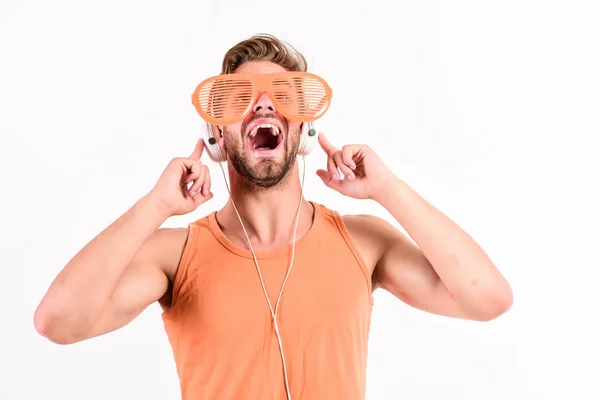 Емоційний чоловік з навушниками слухає музику. Небезпечний чоловік слухає музику в гарнітурі. сексуальний м'язовий чоловік слухає спортивну музику. людина в навушниках ізольована на білому — стокове фото