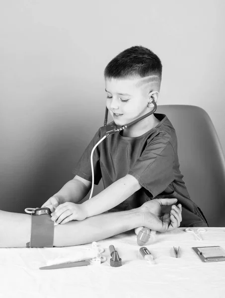 의학 교육. 소년 귀여운 아이 미래 의사 경력. 의료. 아이 작은 의사는 청진기와 의료 도구와 함께 테이블을 앉아있다. 의학 개념. 혈압 측정. 건강 검진 — 스톡 사진